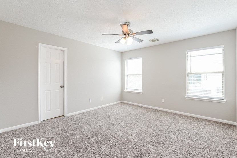 a bedroom with carpet and a ceiling fan