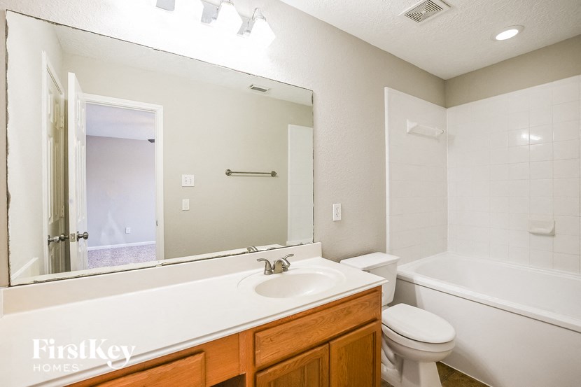 a bathroom with a large mirror and a sink and a toilet