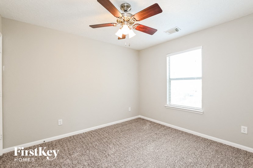 a bedroom with a ceiling fan and a window