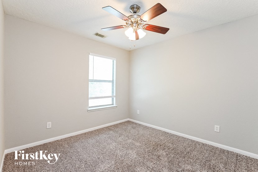 a bedroom with a ceiling fan and a window