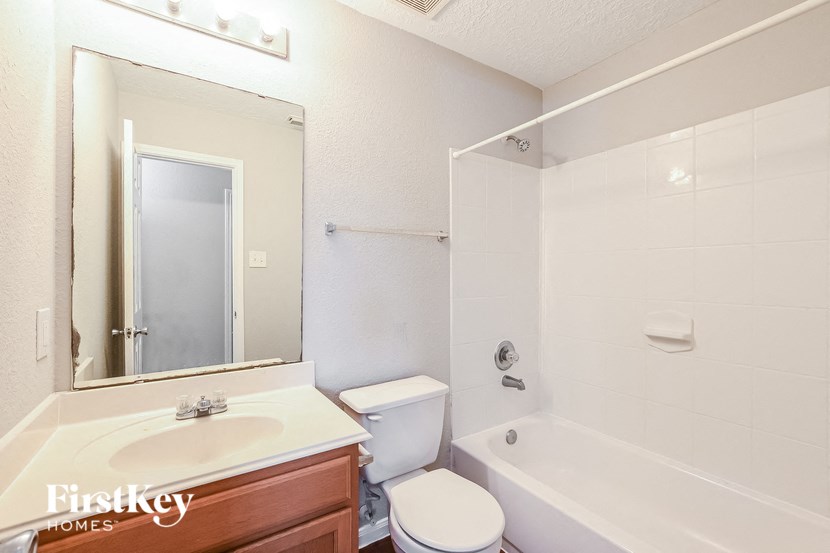 a bathroom with a sink toilet and tub and a mirror