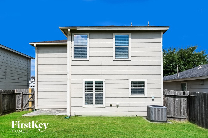 a home with white siding and a trash can in the yard