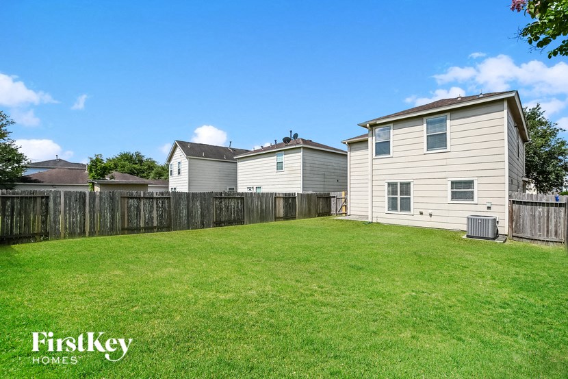a backyard with a wooden fence and two houses