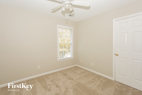 a bedroom with carpet and a ceiling fan