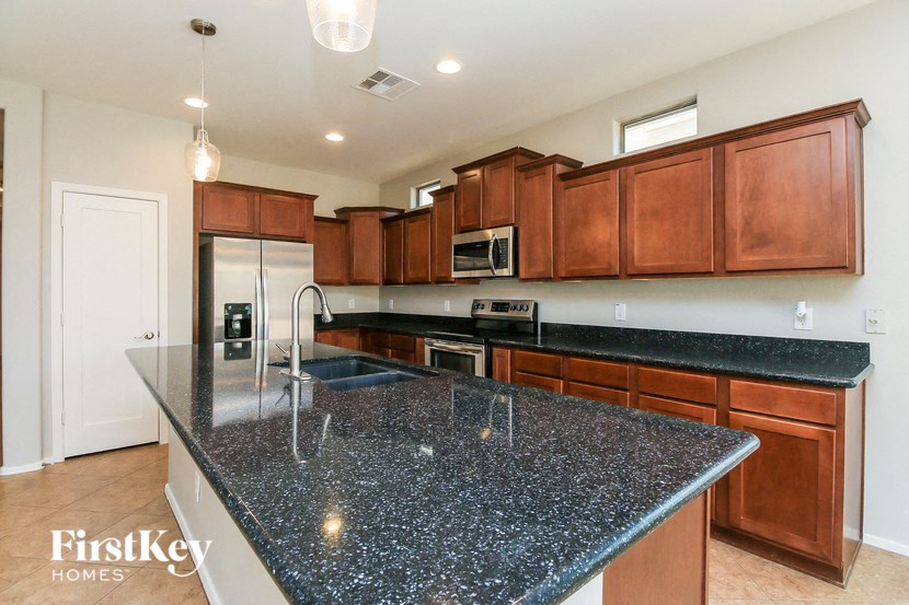 a kitchen with granite counter tops and wooden cabinets