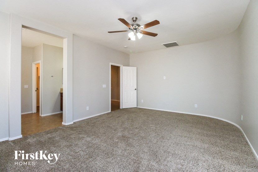 an empty living room with a ceiling fan