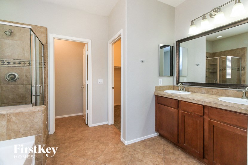 a bathroom with two sinks and a shower and a mirror