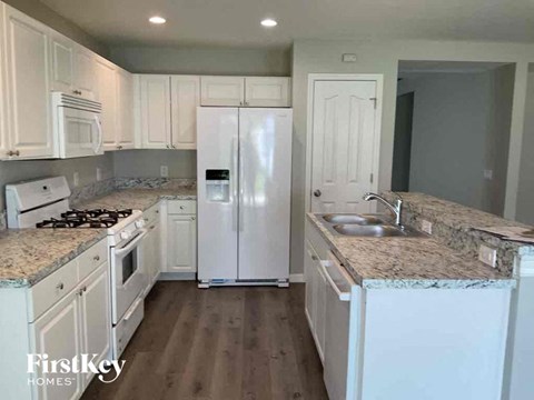 A kitchen with white appliances and cabinets.