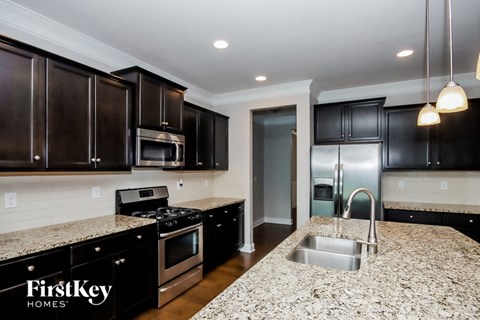 a kitchen with black cabinets and granite counter tops