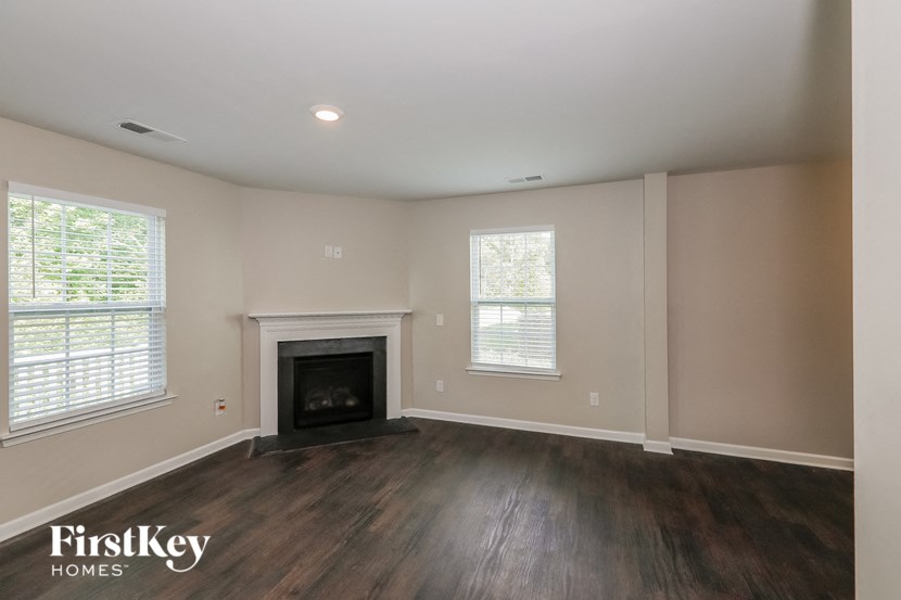 the living room of a home with wood flooring and a fireplace