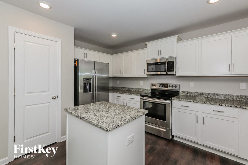 a kitchen with white cabinets and stainless steel appliances