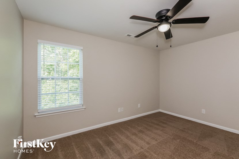 a bedroom with a ceiling fan and a window