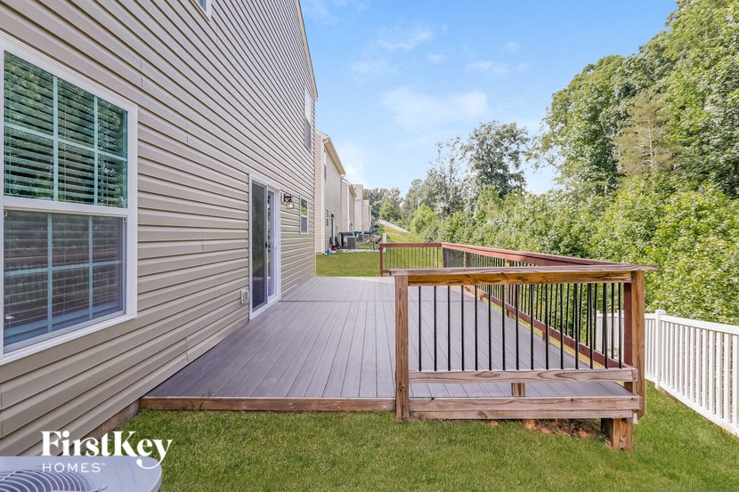 a backyard deck with a fence and a house