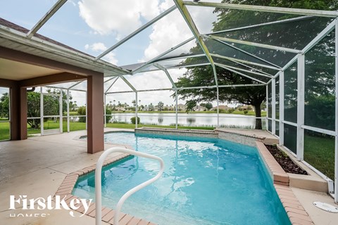 A swimming pool under a glass roof with the words "FirstKey Homes" on the bottom.