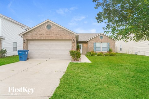 a home with a white garage door and a green lawn