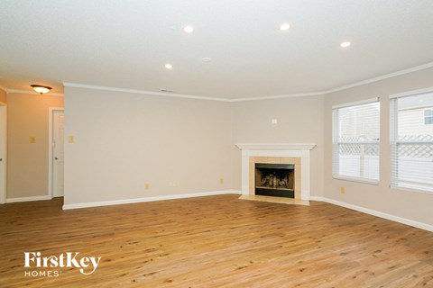 a living room with a fireplace and a wooden floor