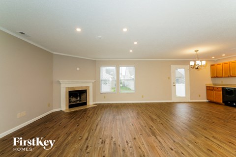 the living room with wood flooring and a fireplace