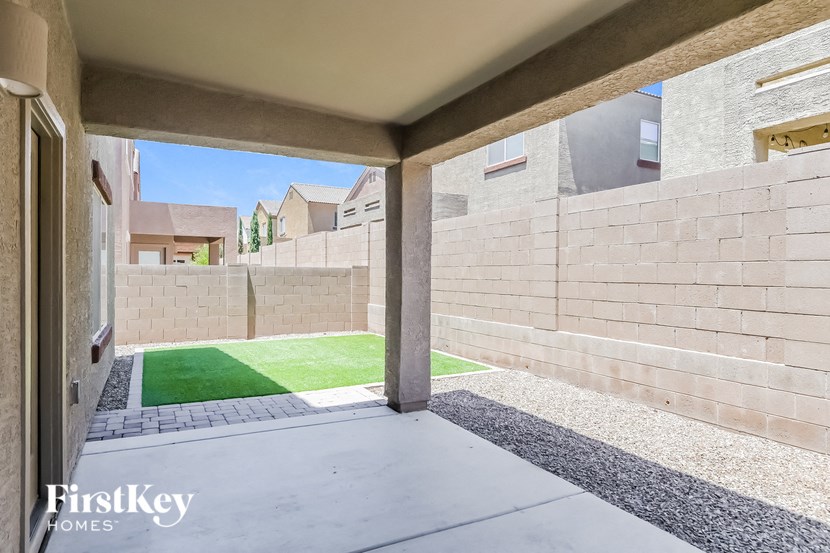 A view from a covered walkway looking out to a grassy area.