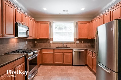 A kitchen with wooden cabinets and a stainless steel refrigerator.