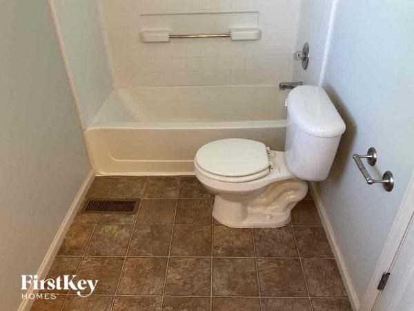 a small bathroom with a toilet and a bath tub