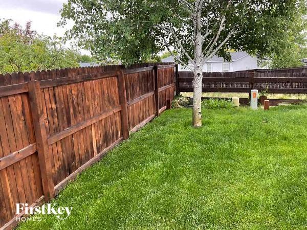 a wooden fence in a yard with a tree