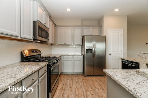 a kitchen with white cabinets and a stainless steel refrigerator
