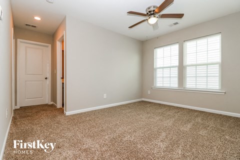 a empty room with a ceiling fan and a door