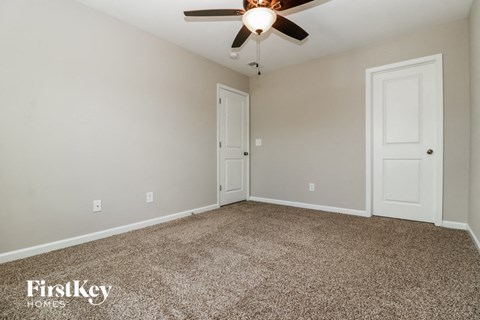 a empty room with a ceiling fan and a door