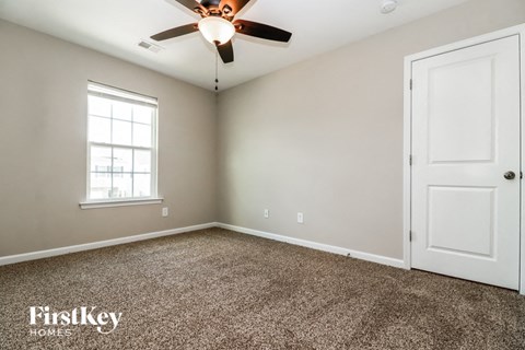 a bedroom with a ceiling fan and a white door