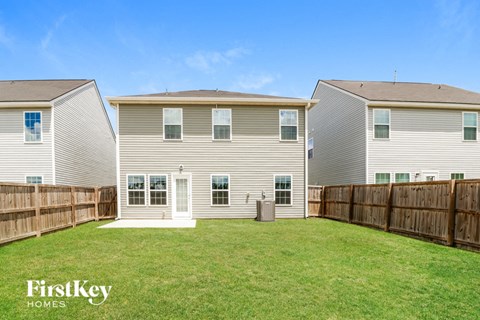 the backyard of a house with a yard and a wooden fence
