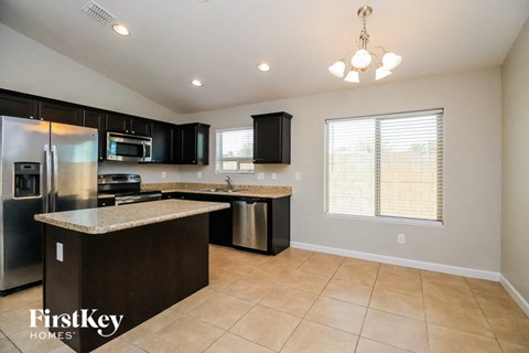a kitchen with an island and a stainless steel refrigerator