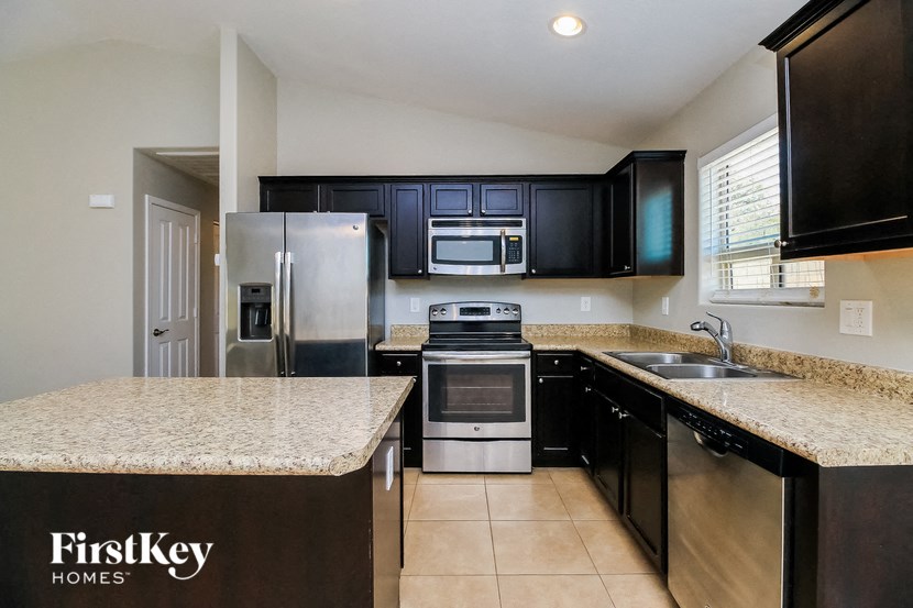 a kitchen with granite counter tops and black cabinets
