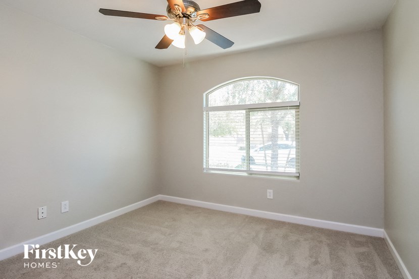 a bedroom with a ceiling fan and a window