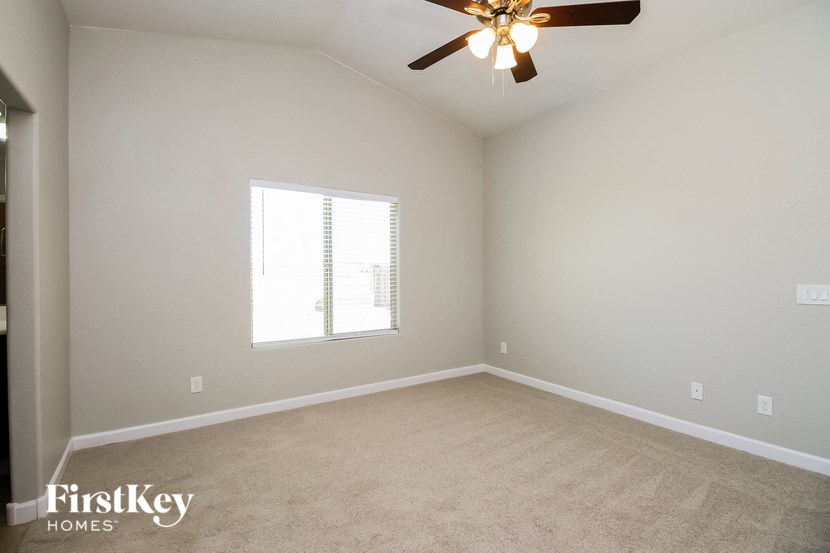 a empty room with a ceiling fan and a window
