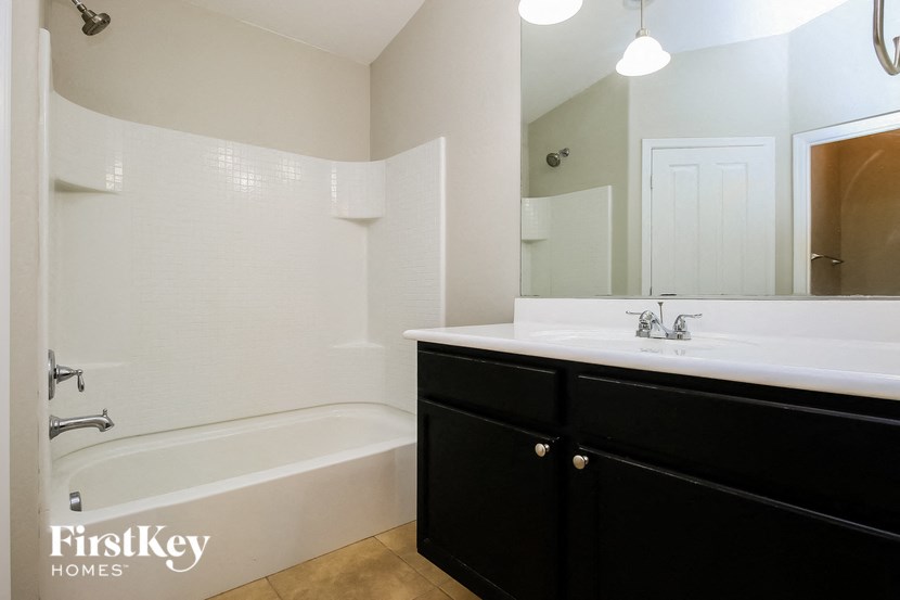 a bathroom with a sink and a tub and a mirror