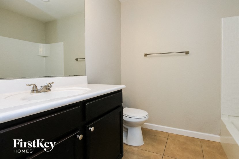 a bathroom with a sink toilet and a mirror