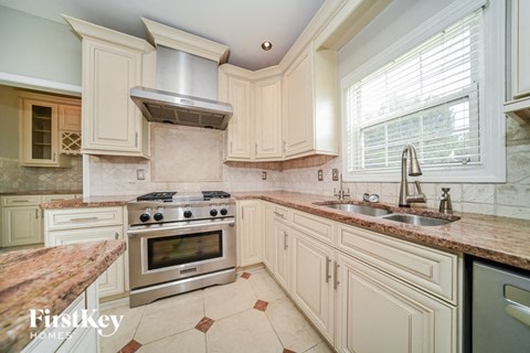 a large kitchen with white cabinets and stainless steel appliances