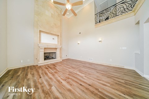 the living room has a fireplace and wood flooring