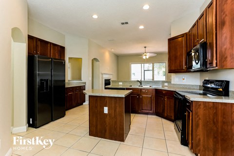 a large kitchen with black appliances and wooden cabinets