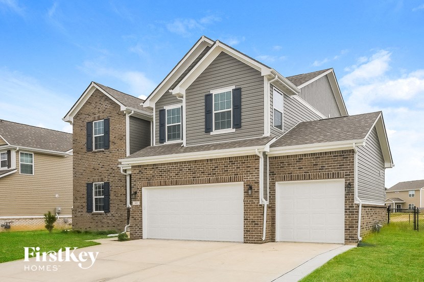 a brick house with two garage doors