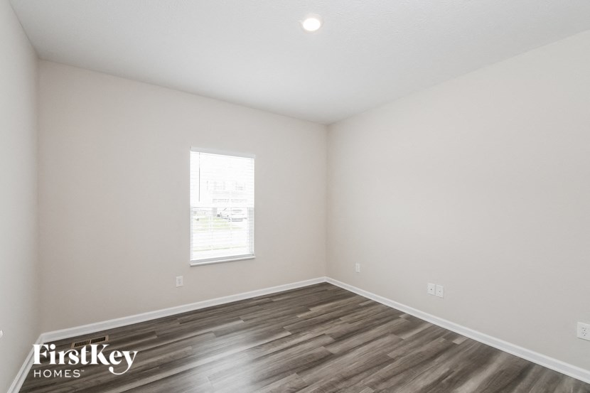 an empty room with wood flooring and a window