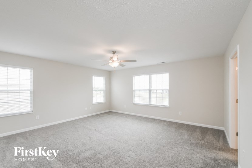 a living room with a ceiling fan and windows