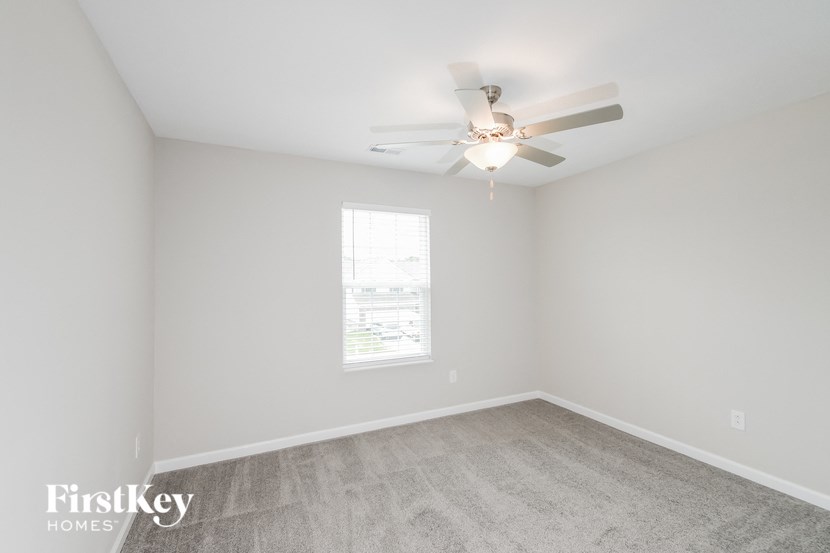 a bedroom with a ceiling fan and a window