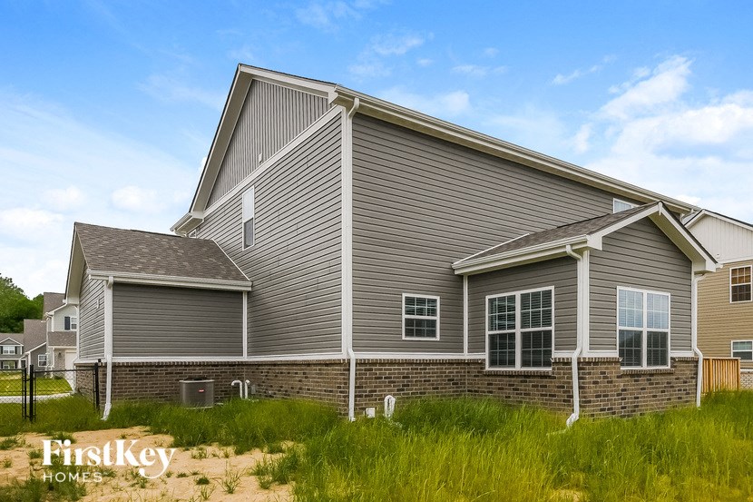 side view of a gray house with brick and siding