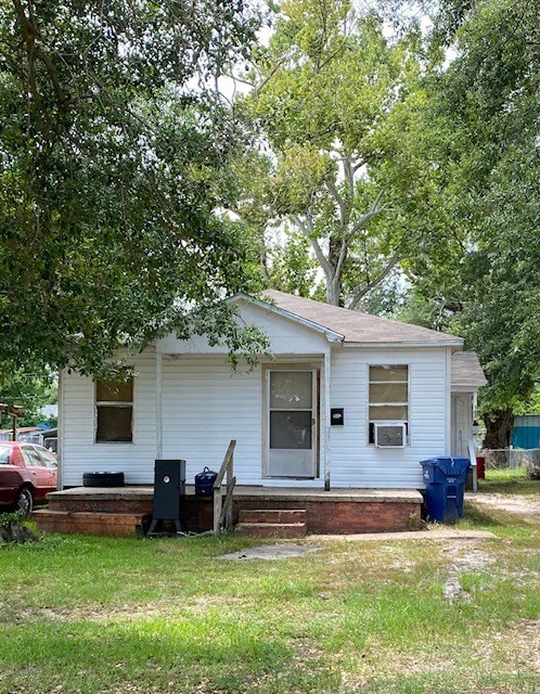a small white house with a porch and some trees