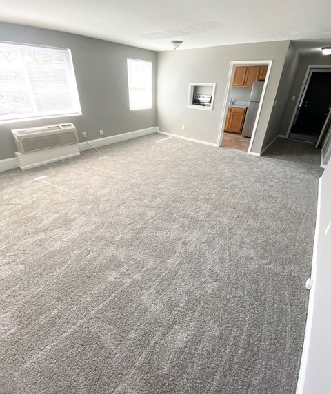 an empty living room with a carpeted floor