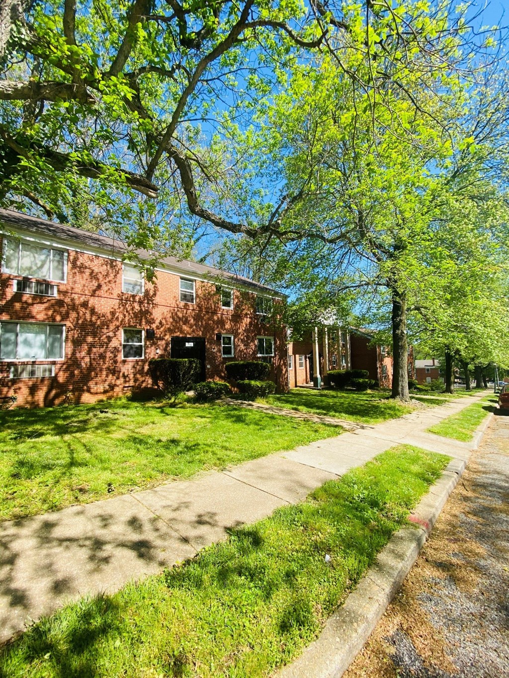 a sidewalk in front of a brick house