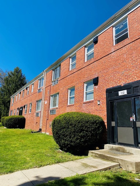 a brick building with steps and grass in front of it