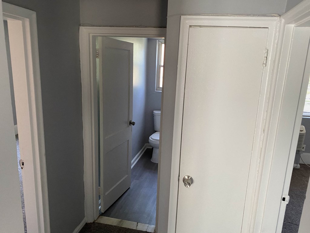 the door is open to the bathroom and the door to the closet is closed