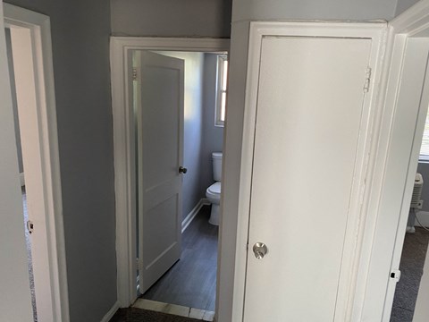 the door is open to the bathroom and the door to the closet is closed